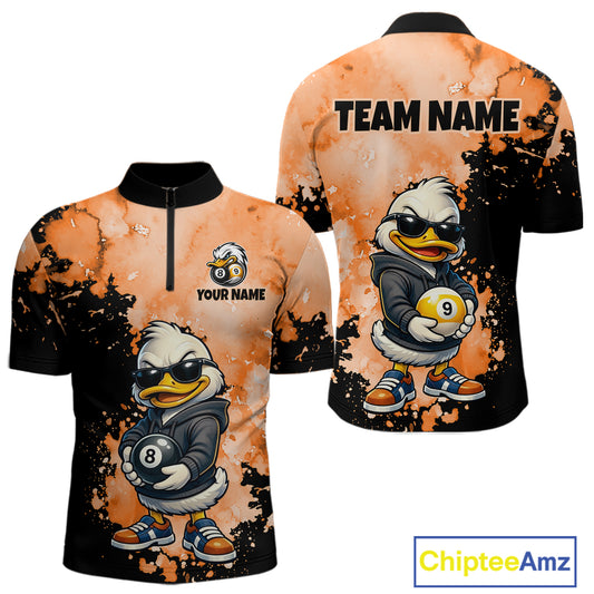 Front and back views of a short-sleeve polo shirt featuring a cartoon duck character in a black hoodie holding pool balls, on an orange splattered background with black sleeves and collar. The front has a half-zip, the back has 'TEAM NAME' text, and the shirts show customizable text placeholders.