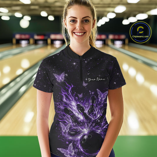 Female model wearing a black and purple bowling quarter-zip shirt at the lane with cosmic bowling strike artwork.