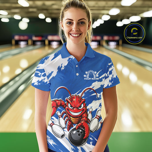 Front view of a female model in a bowling alley wearing a blue custom bowling polo shirt with a fierce yet funny crawfish bowling character and a distressed background design.