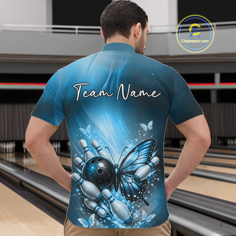 Front view of a male model in a bowling venue wearing a blue quarter-zip shirt featuring a butterfly beside a bowling ball and pins.