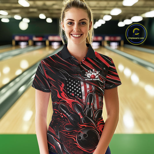 Female model at a bowling lane wearing a black and red bowling polo shirt with patriotic bowling action artwork and fiery pin graphics.