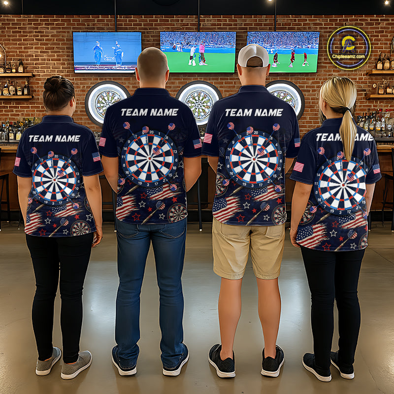 Four people standing with their backs to the camera in a bar setting, wearing matching navy blue short-sleeve shirts with a large dartboard graphic, American flag motifs, and 'TEAM NAME' printed across the upper back.