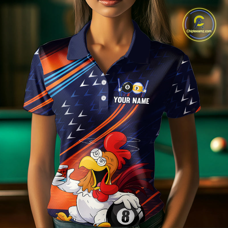 A woman wearing a custom dark blue polo shirt with a racing and billiards theme, featuring a cartoon rooster holding a 8-ball and the text 'YOUR NAME'. The background shows a blurred pool table.