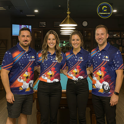 Four people standing indoors in matching blue polo shirts with a large cartoon rooster graphic and diagonal orange, white, and red stripes. The shirts also include small white text reading 'YOUR NAME'