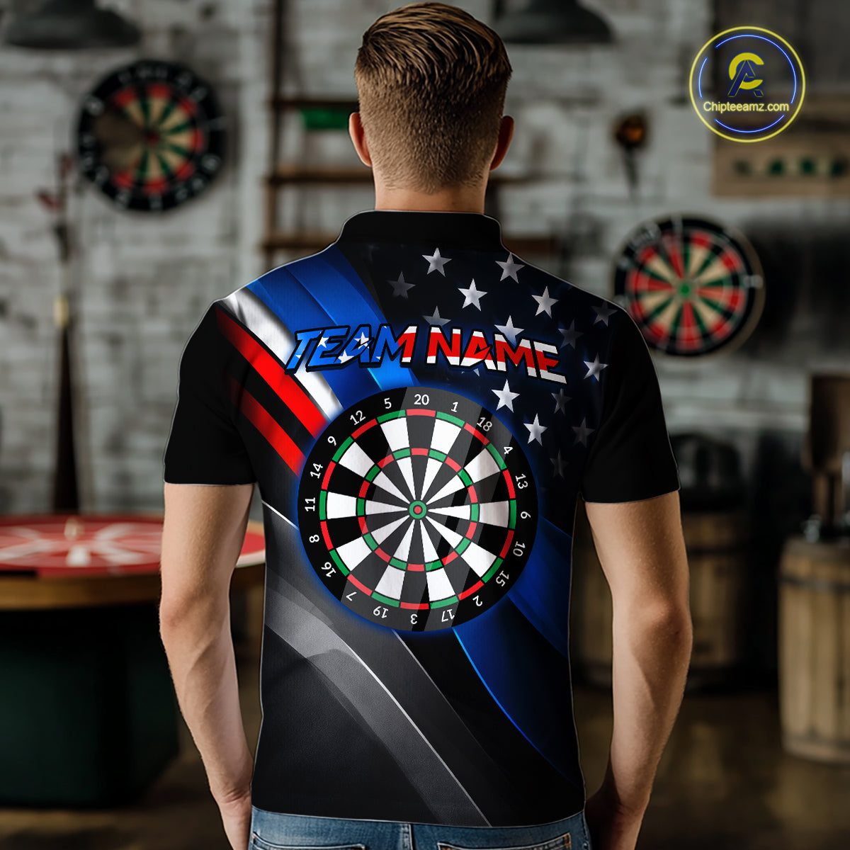 Back view of a man wearing a custom dart polo with personalized team name and a patriotic dartboard graphic with red, blue, and silver diagonal stripes in a professional dart room.