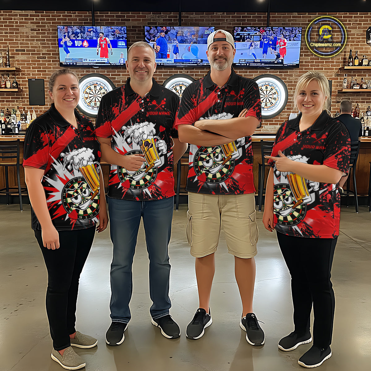Four people standing together in a bar or lounge setting, wearing matching black short-sleeve polo shirts with a red, white, and gray graphic design featuring beer glasses and a dartboard motif. The background shows brick walls, multiple sports TVs, dartboards, and bar fixtures.