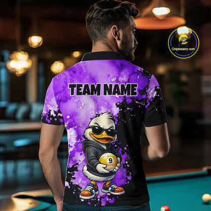 A man viewed from behind wearing a custom-printed polo shirt with a purple and black watercolor design, featuring a cartoon duck character holding a billiard ball and the text 'TEAM NAME' on the back. The background shows a blurred billiards room with a green pool table.