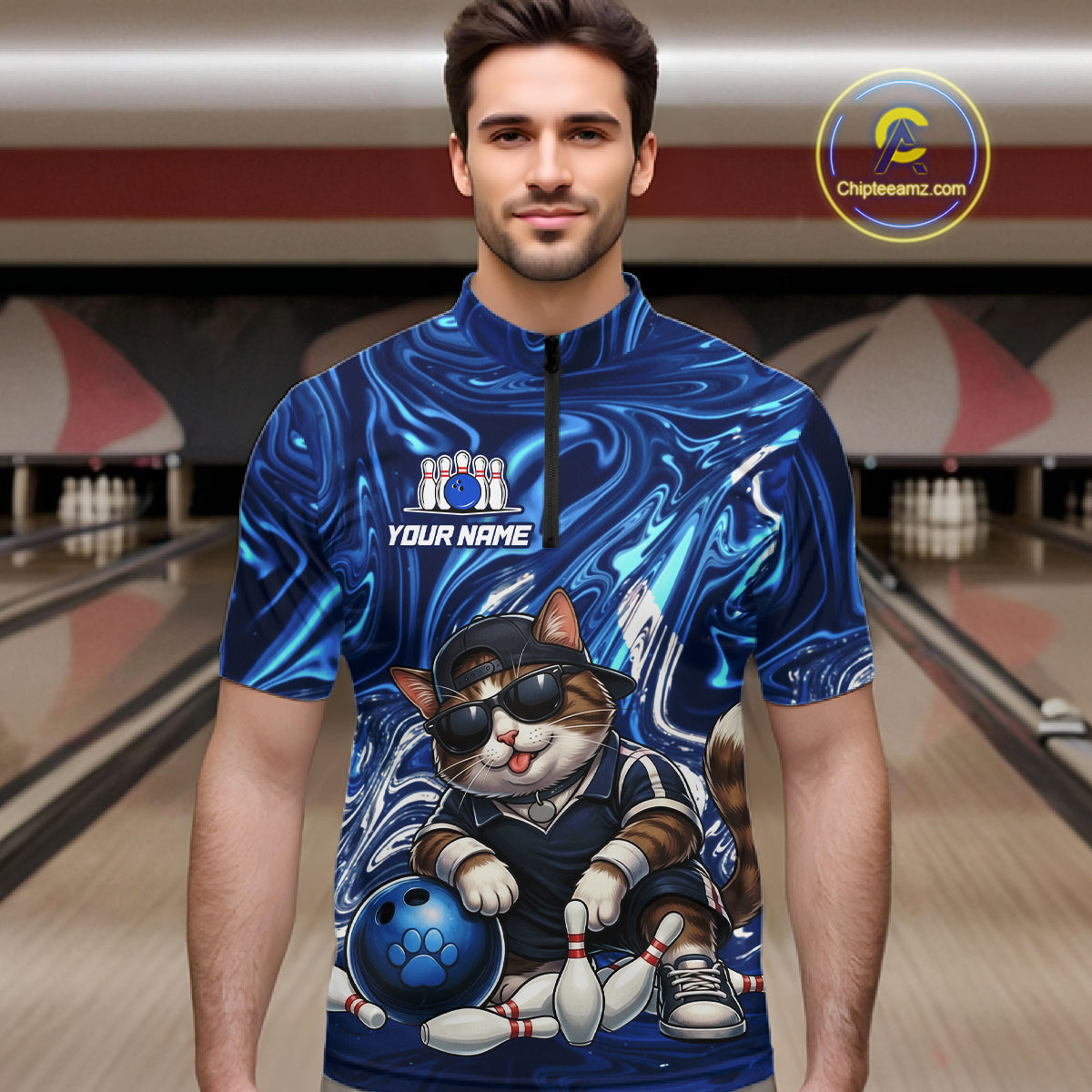 Man wearing a blue bowling jersey with a cat graphic in a bowling alley.