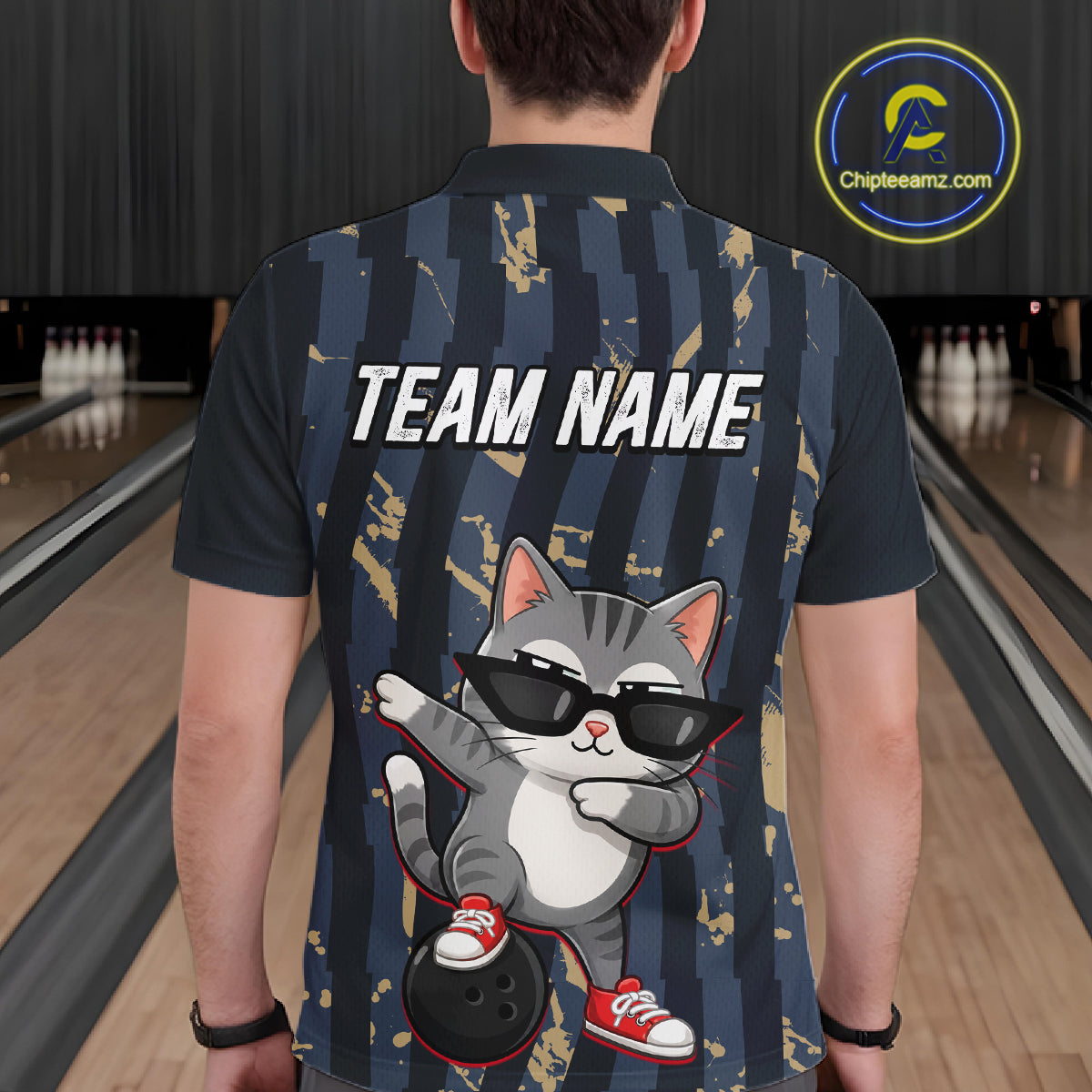 Person wearing a bowling shirt with a cat graphic and 'TEAM NAME' text in a bowling alley.