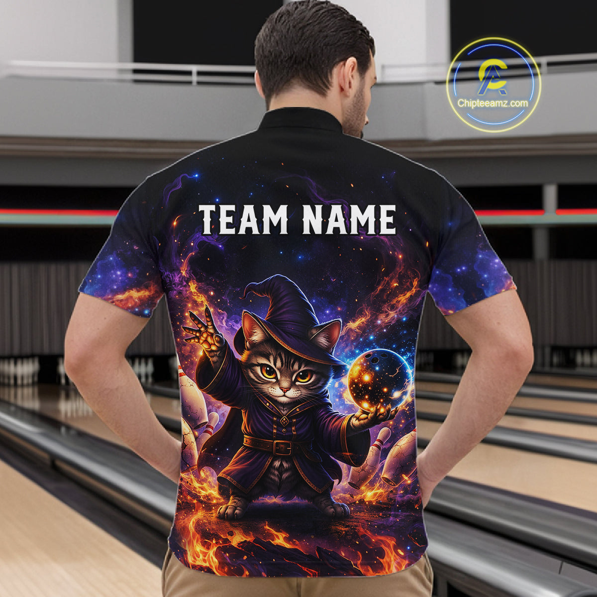 Person wearing a black t-shirt with a cat wizard design and 'TEAM NAME' text in a bowling alley.