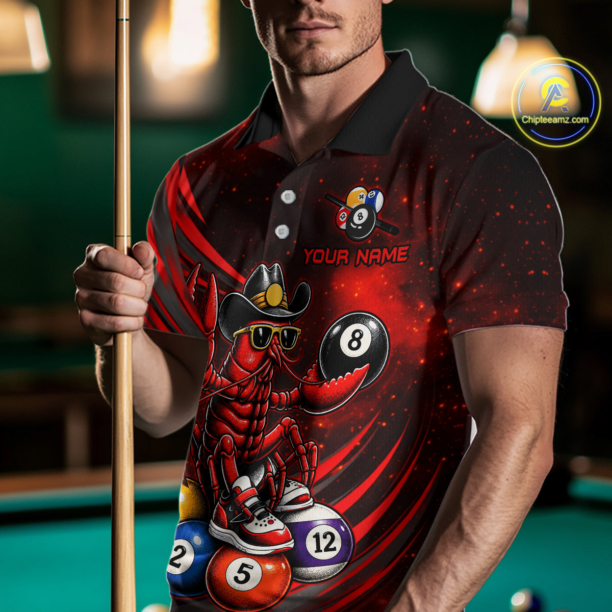 Person wearing a black and red polo shirt with a lobster and pool ball design, holding a pool cue.