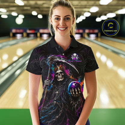 A woman stands in a bowling alley wearing a black short-sleeve polo shirt with a colorful graphic of a grim reaper holding a scythe and bowling ball, with a 'Your Name' placeholder print.