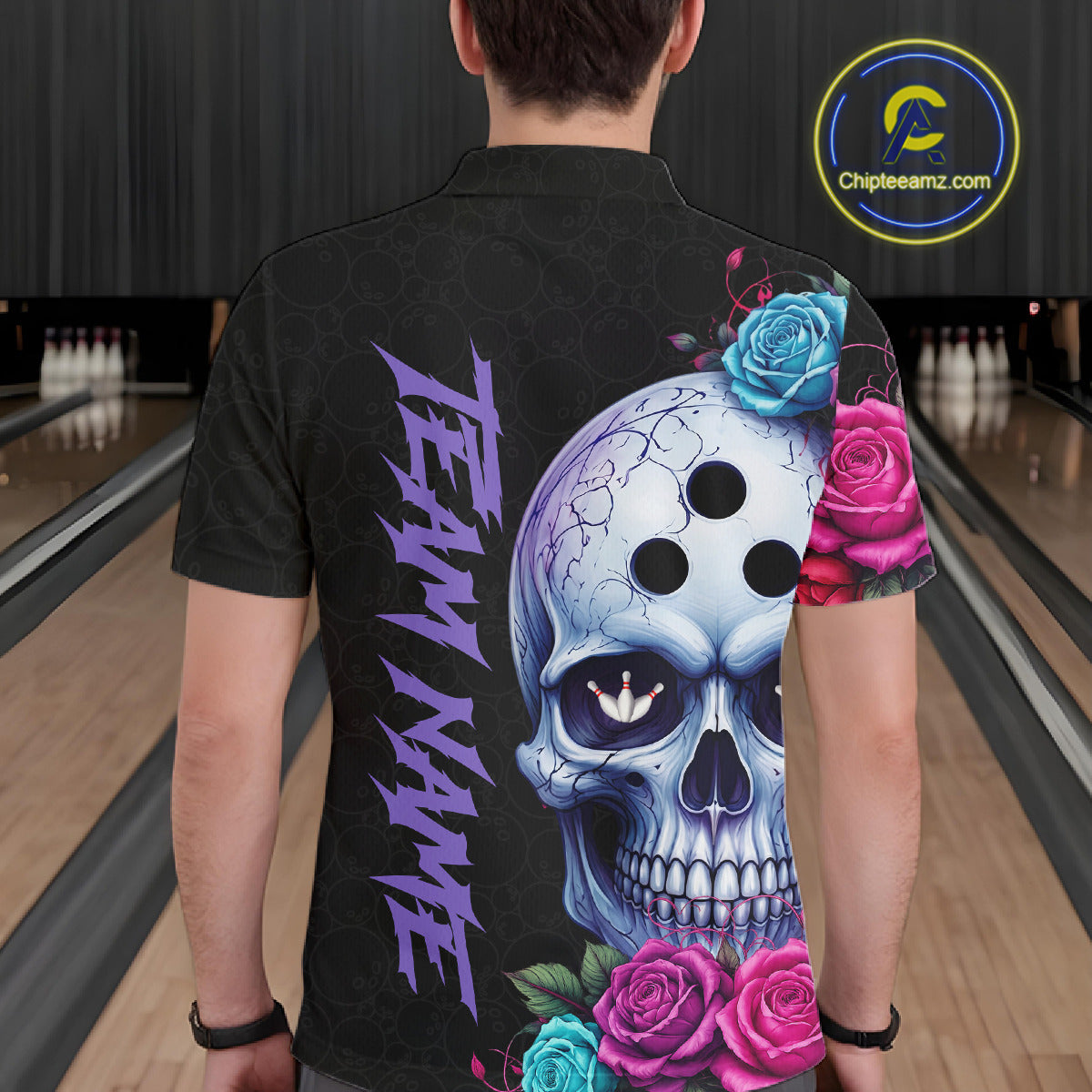 Person wearing a black shirt with a colorful skull and roses design in a bowling alley.