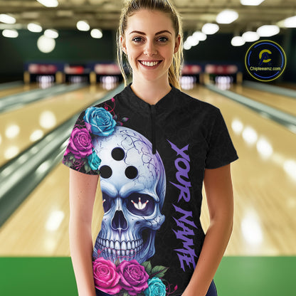 Woman wearing a black bowling jersey with a colorful skull design in a bowling alley.