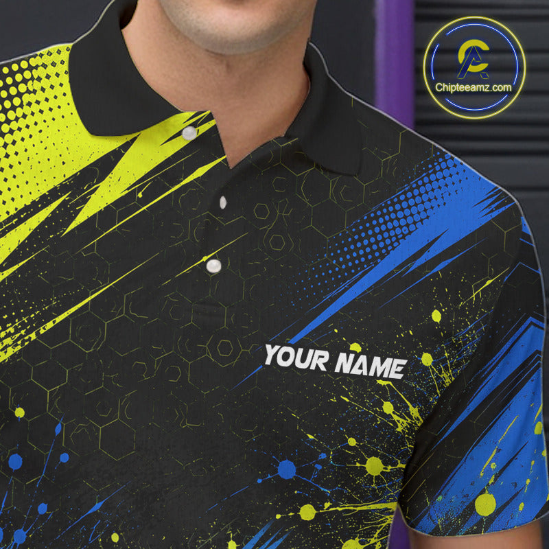 A close-up of a man wearing a black short-sleeve polo shirt with a vibrant neon yellow and blue abstract pattern, featuring a white 'YOUR NAME' placeholder print on the chest.