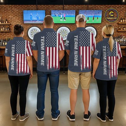 Four people standing with their backs to the camera in a bar, wearing matching navy blue t-shirts with a distressed American flag graphic on the back and 'TEAM NAME' printed vertically down the left shoulder.