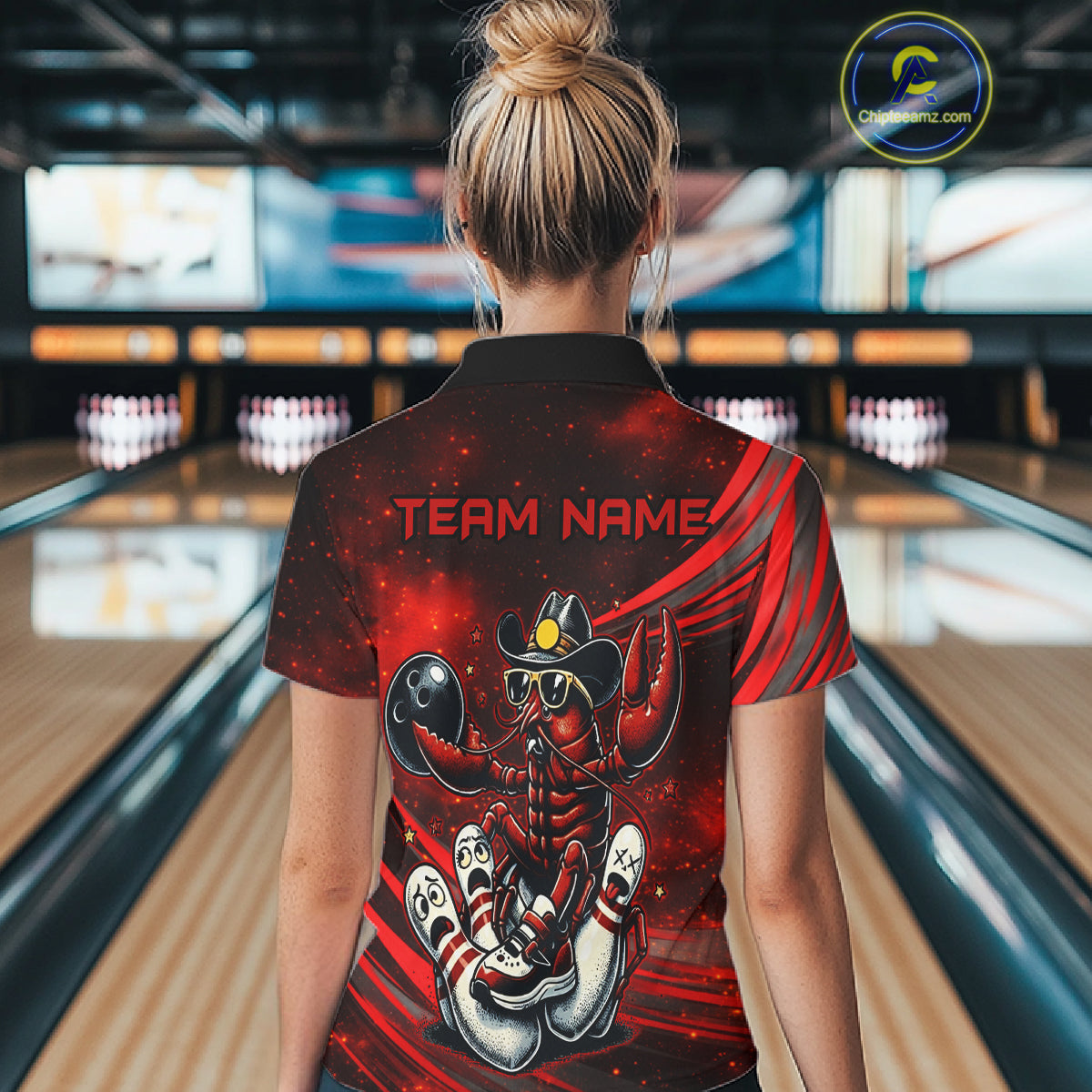 Person wearing a red and black shirt with a crawfish design and 'TEAM NAME' text in a bowling alley.
