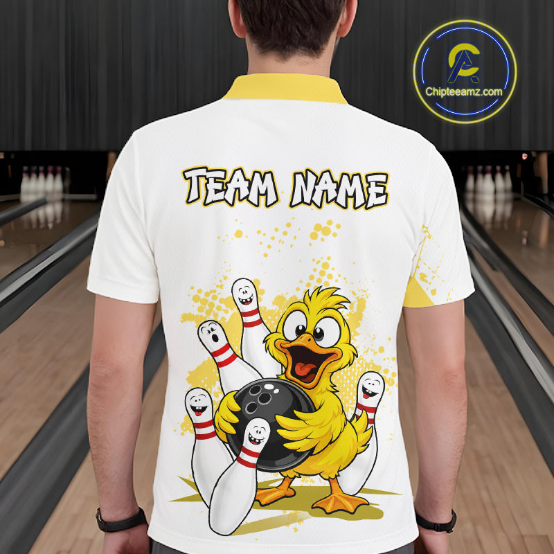 A man viewed from behind wearing a white short-sleeve polo shirt with a yellow collar, featuring a cartoon yellow chick holding bowling pins and a bowling ball, with the text 'TEAM NAME' across the upper back. The background shows a bowling alley with lanes and pins.