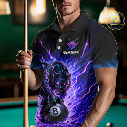 Man wearing a black polo shirt with a panther and pool ball design, holding a pool cue on a billiard table.