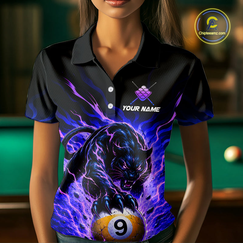 Person wearing a black shirt with a panther and pool ball design, with a blurred background of a pool table.
