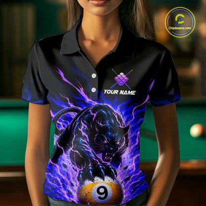 Person wearing a black shirt with a panther and pool ball design, with a blurred background of a pool table.