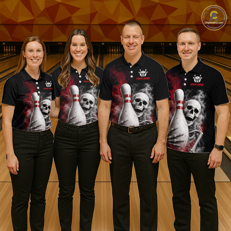 Four people standing together in a bowling alley wearing matching black short-sleeve polo shirts with a large graphic print of a skull and bowling pins, paired with black pants. 