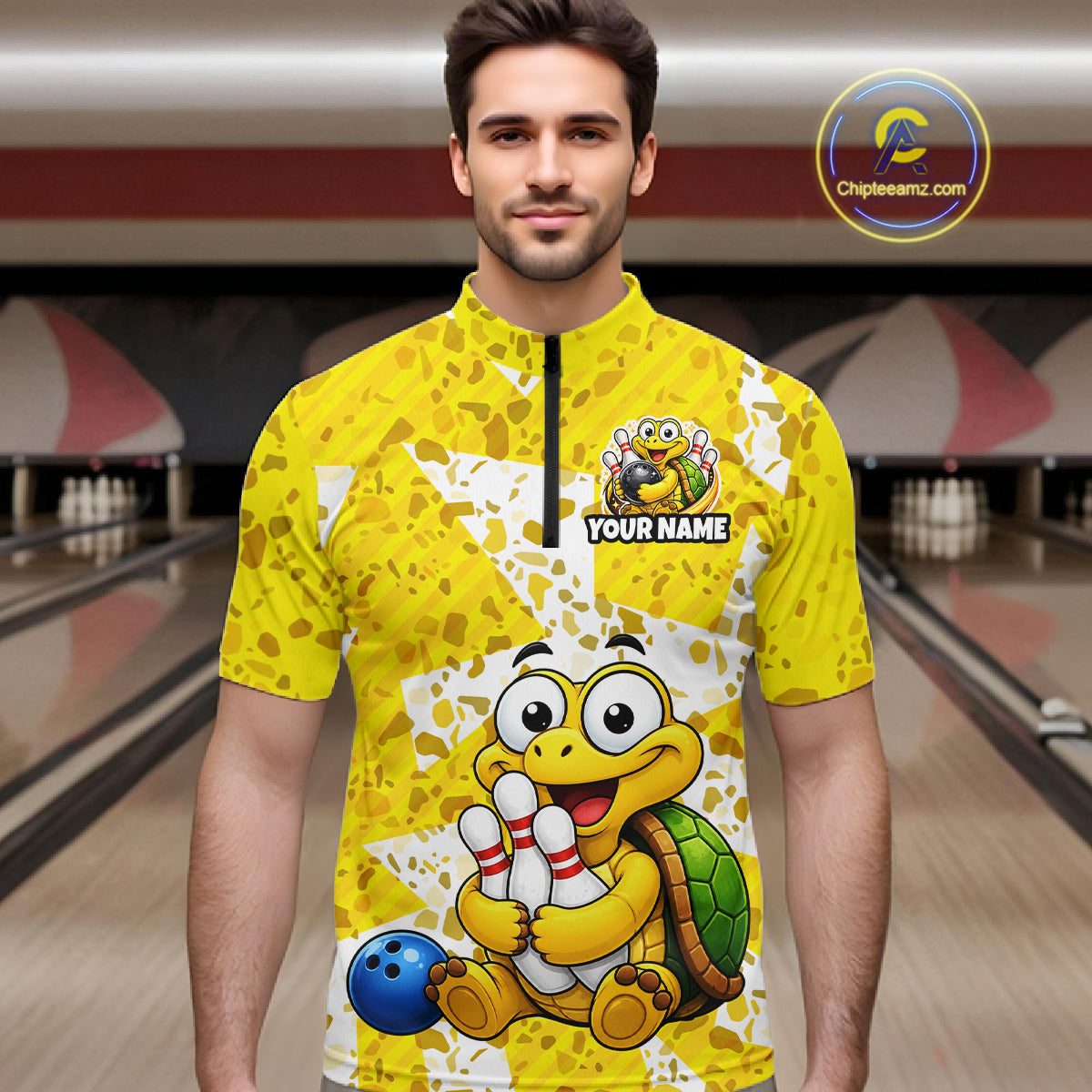 Man wearing a yellow bowling jersey with cartoon turtle design in a bowling alley.