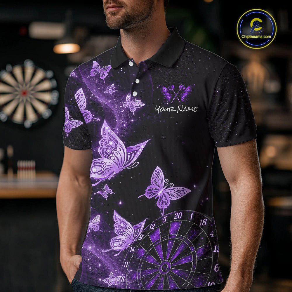 A man wearing a black short-sleeve polo shirt with a purple and lavender butterfly and dartboard graphic design, featuring a customizable name print on the chest. The background is a blurred indoor setting with a dartboard.