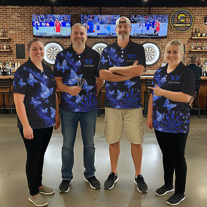 Four people standing together in a bar or lounge setting, wearing matching dark blue polo shirts with a butterfly and dartboard pattern. 