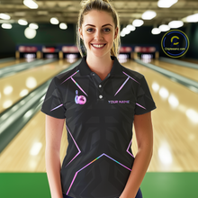 Load image into Gallery viewer, Woman wearing a black bowling shirt with colorful designs in a bowling alley.
