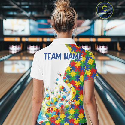 Female model at a bowling lane, back view of white polo shirt showcasing autism bowling strike artwork with vibrant puzzle elements