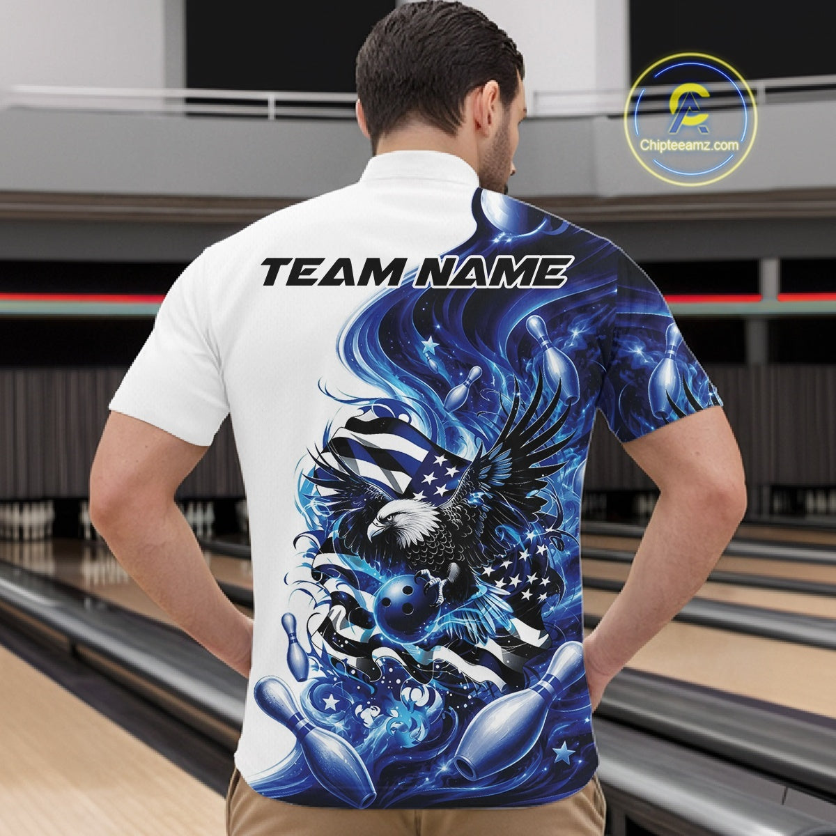 Male model front view at the bowling lane wearing a white and blue bowling quarter zip shirt with eagle artwork and flag inspired accents.