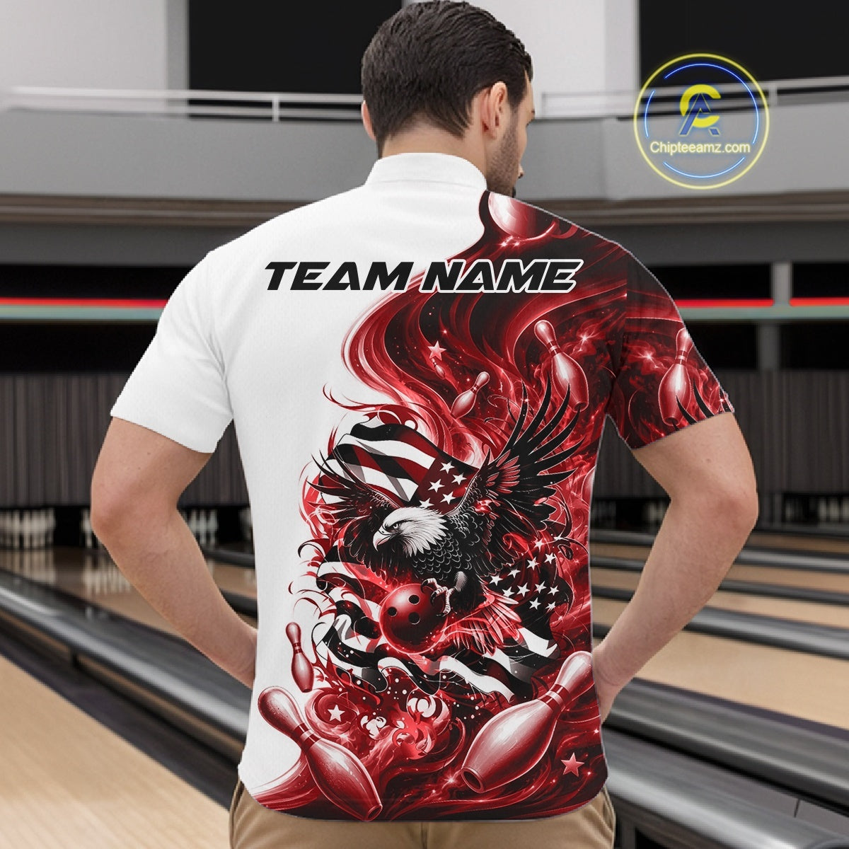 Male model front view at the bowling lane wearing a white and red bowling quarter zip shirt with eagle artwork and American flag inspired graphics.