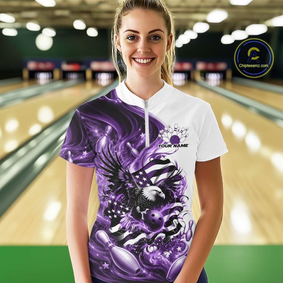 Front view female model in a bowling lane wearing a white and purple bowling quarter zip shirt with eagle graphics and flag inspired artwork.
