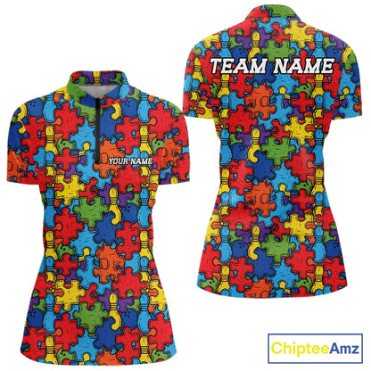 Front and back views of a short-sleeve polo shirt featuring a colorful autism awareness puzzle piece pattern. The front has a quarter-zip collar and the text 'YOUR NAME', while the back has 'TEAM NAME'.