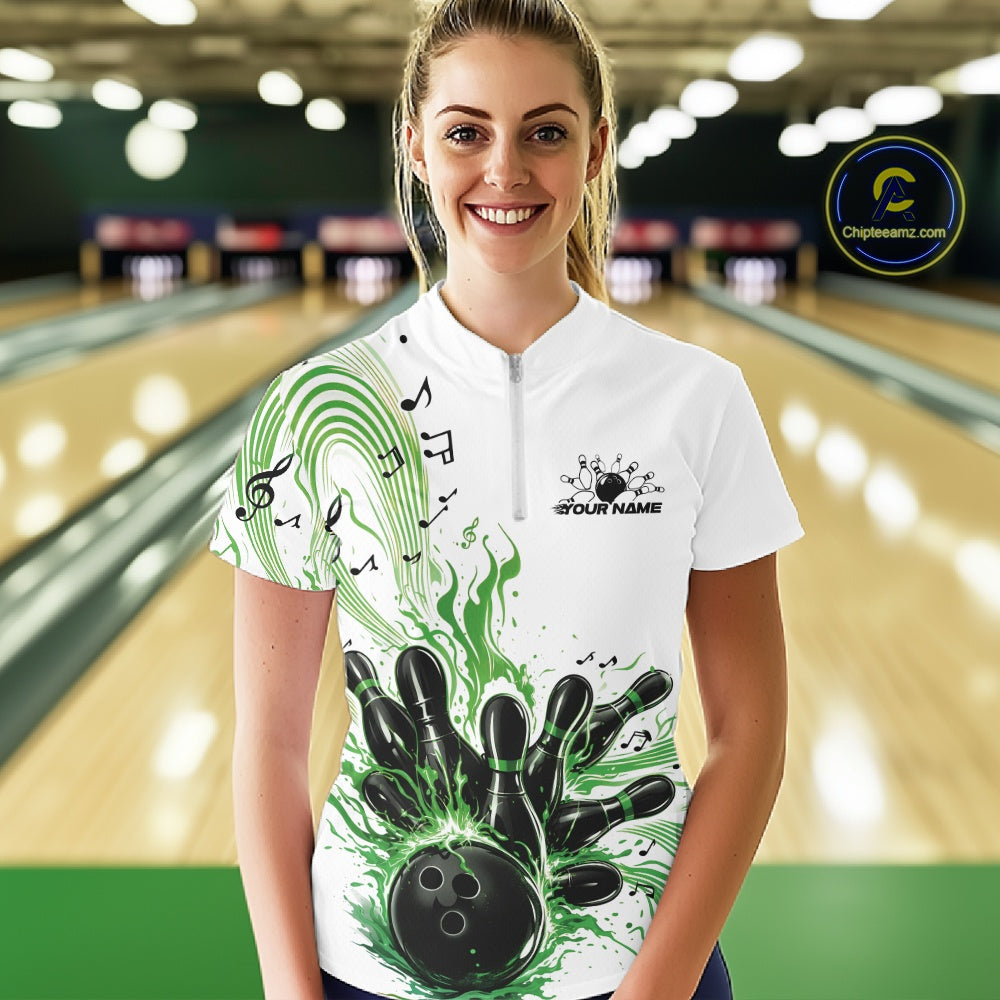 Female model wearing a white and green bowling quarter-zip shirt at the lane with bowling strike artwork and music-themed wave graphics.