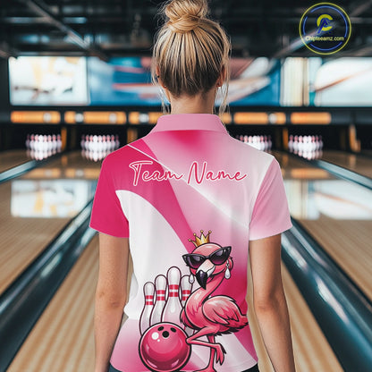 Back view of a female model in a bowling venue wearing a pink quarter-zip shirt featuring a crowned flamingo and bowling ball artwork.
