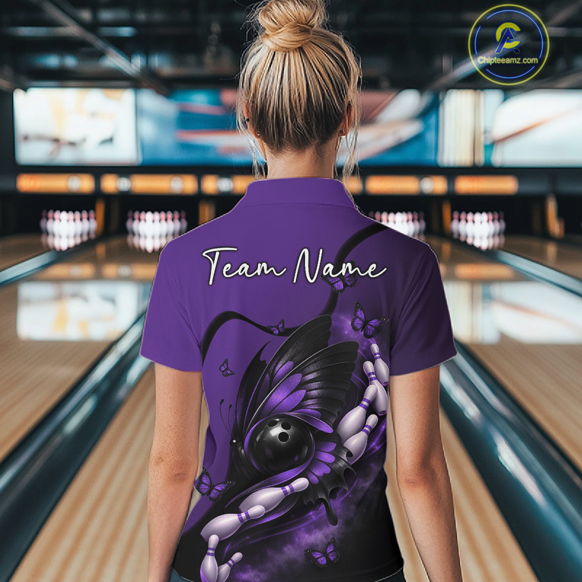 Back view of a female model wearing a purple and black bowling quarter-zip shirt showcasing a butterfly wrapped around a bowling ball.