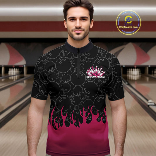 Male model in a bowling alley wearing a black quarter zip shirt, front view featuring bowling ball pattern with vibrant pink flames rising from the bottom and flaming bowling-themed graphics