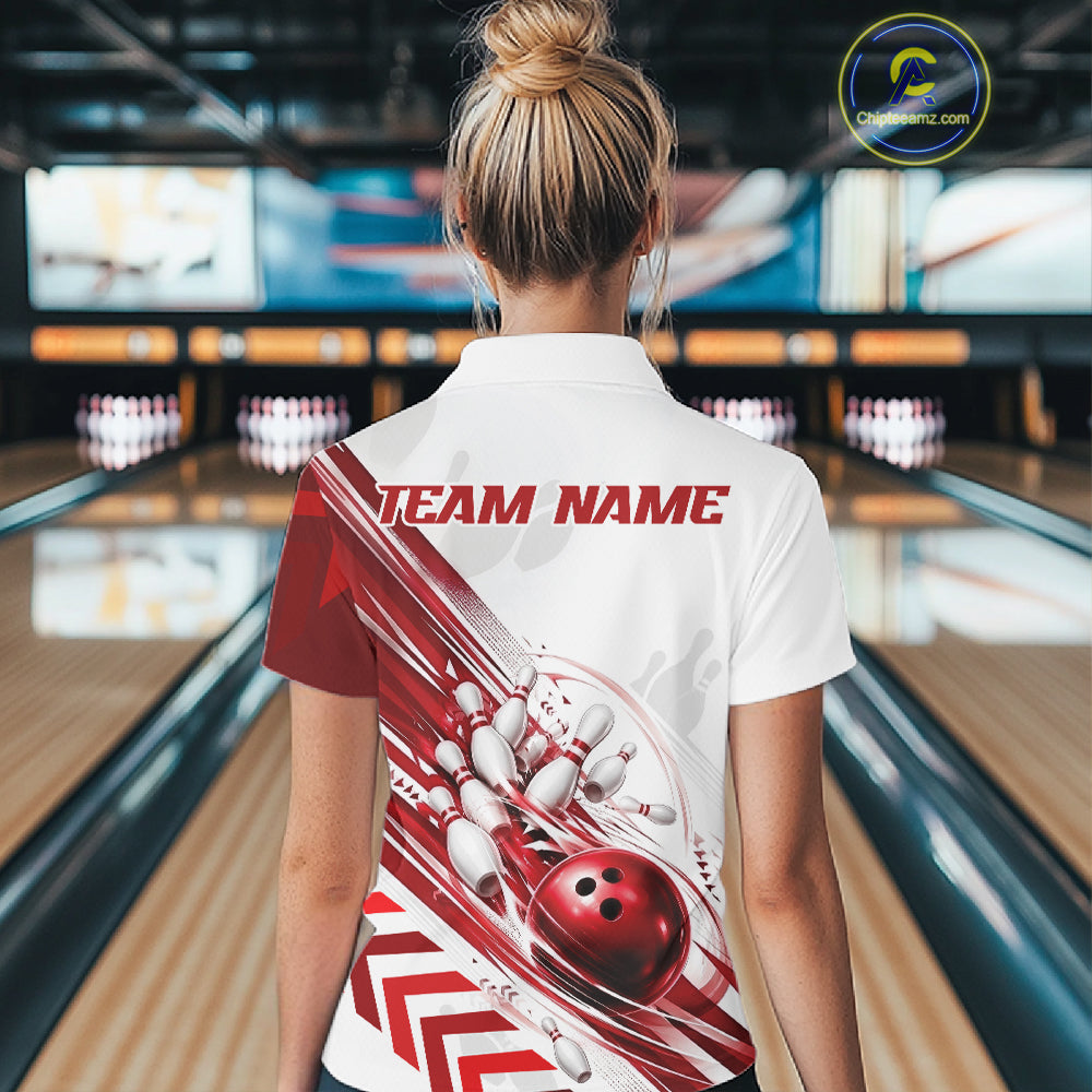 A woman viewed from behind wearing a white short-sleeve bowling-themed polo shirt with a red and white graphic design on the back, standing in a bowling alley.