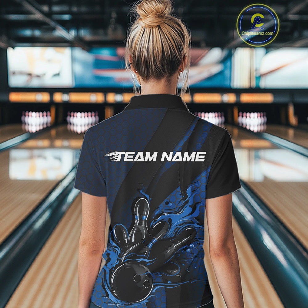 Female model inside a bowling center, back view of black and blue quarter zip shirt highlighting flames bowling ball striking pins with structured hexagon and stripe patterns