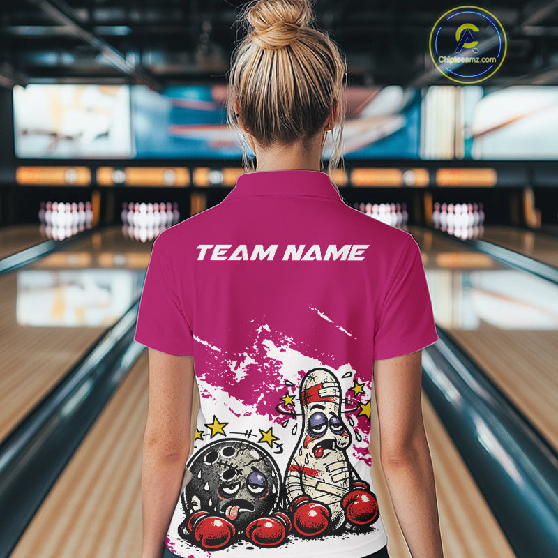 Back view of a female bowler wearing a pink and white quarter-zip shirt, boxing-style bowling ball and pin illustration on the shirt.