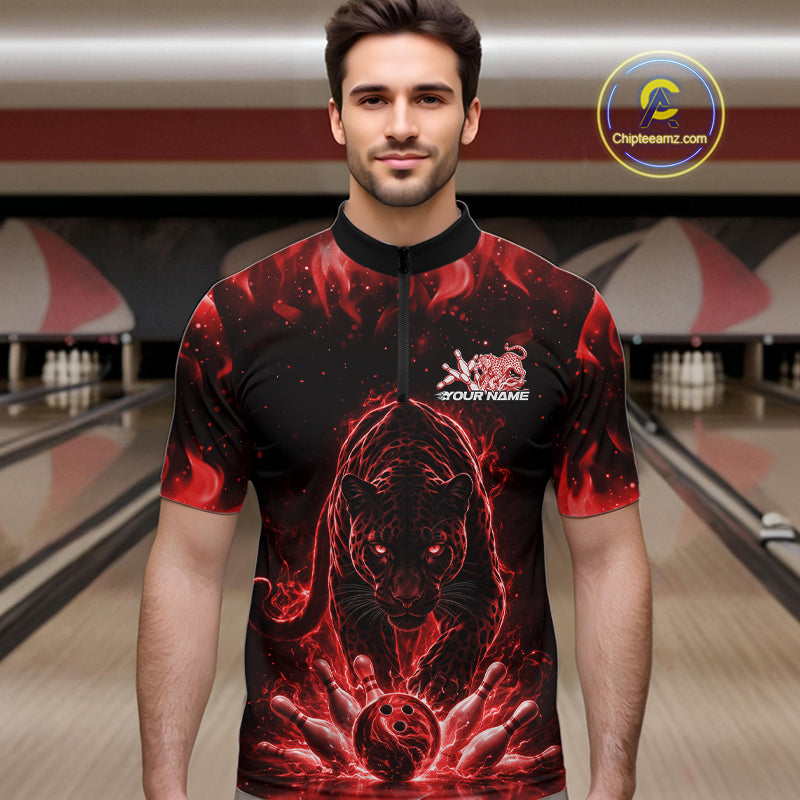 Front view of a male model in a bowling lane wearing a black quarter-zip shirt with glowing red electric panther and dynamic bowling strike visuals.