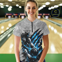 Load image into Gallery viewer, Front view of a female model wearing a gray bowling quarter zip shirt featuring a dramatic blue bowling ball and pins graphic with claw-mark artwork in a bowling lane.