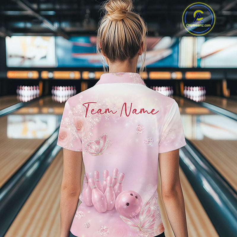 Back view of a female model wearing a women’s bowling quarter-zip shirt with pink glitter butterflies, diamonds, bowling pins, and a bowling ball motif.