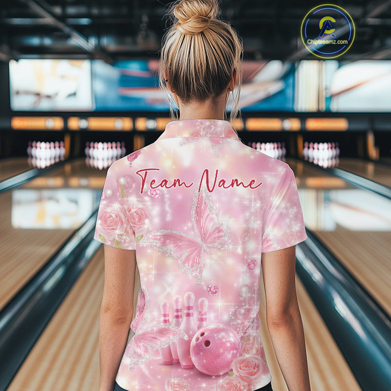 Back view of a female model in a bowling alley wearing a quarter-zip shirt showcasing pink glitter butterflies, diamonds, bowling pins, and bowling artwork.