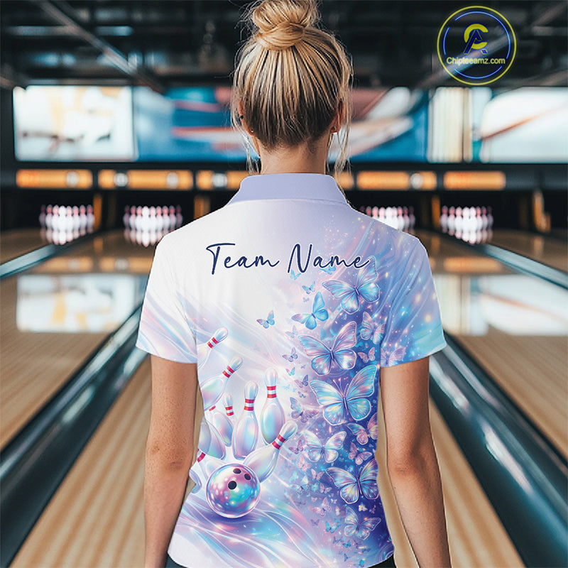 Female model in a bowling quarter zip with pastel purple and pink holographic butterfly artwork and bowling graphics, back view inside a bowling alley
