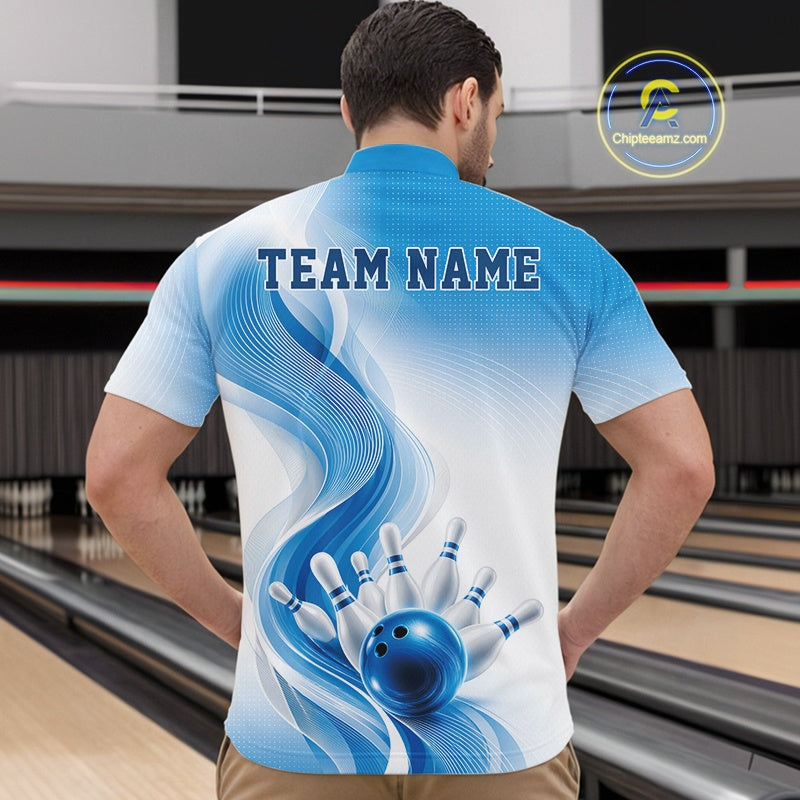 Male model in a white and blue bowling quarter zip showcasing flowing abstract wave accents and a glossy bowling ball striking pins, front view in a bowling alley
