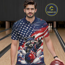 Load image into Gallery viewer, Front view of a male model wearing a bowling polo shirt with a patriotic raccoon, bowling action scene, and flowing American flag artwork inside a bowling lane.