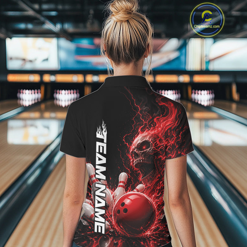 Back view of a female model in a bowling alley wearing a black bowling quarter zip shirt featuring a red fiery skull with lightning striking a bowling ball and pins and a custom name.
